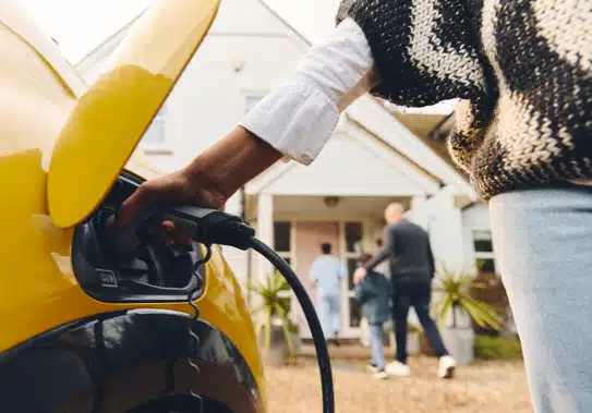 woman charging electric car with EV charger