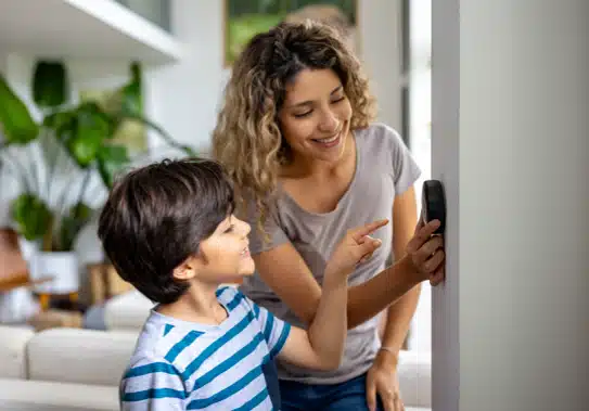mom and son using thermostat